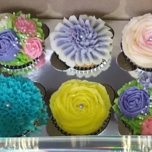 Caja de cupcakes con betún de colores en forma de flores