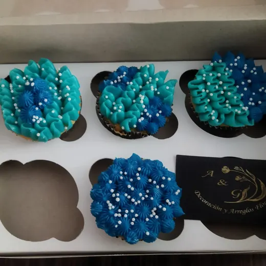 Cupcakes con betún azul y perlas de azúcar en caja