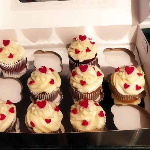 Cupcakes de chocolate con betún blanco y corazones rojos